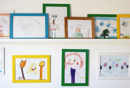 child's drawings displayed on wall at home